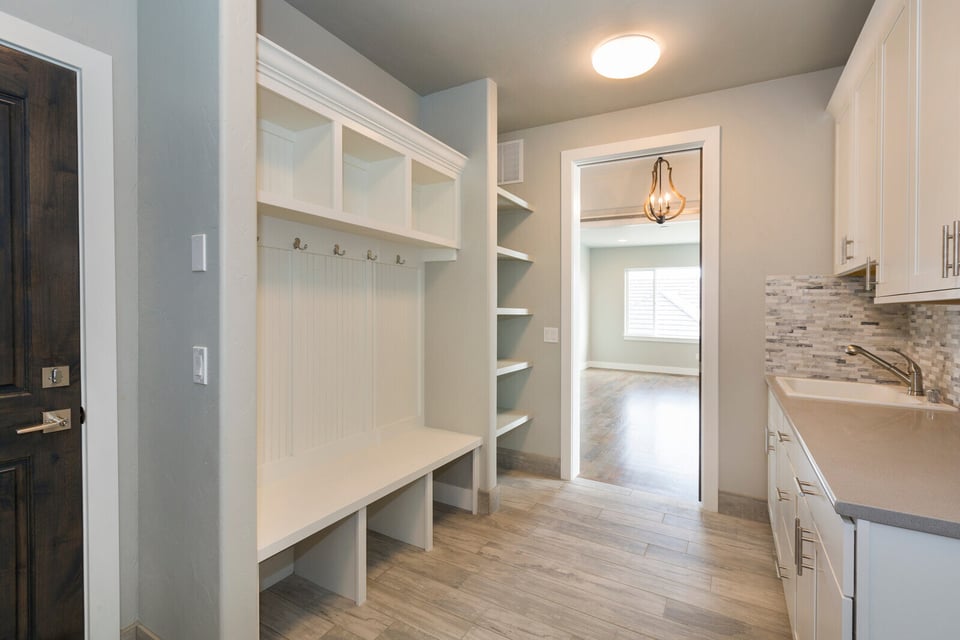 Spacious home addition featuring a white mudroom with custom shelving and contemporary finishes in Durham, NC
