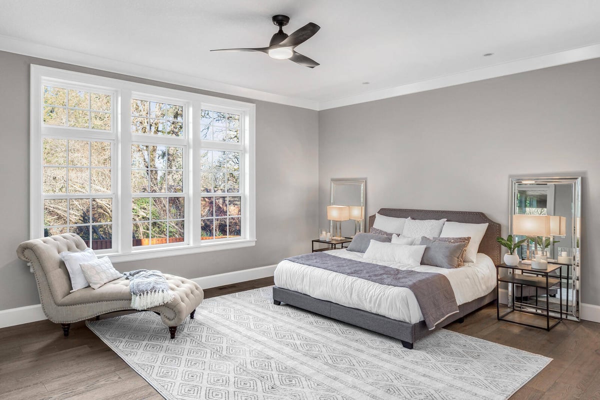 Elegant master bedroom with large windows and soft neutral tones in a whole home remodel by Triple Crown Contractors in Apex, NC