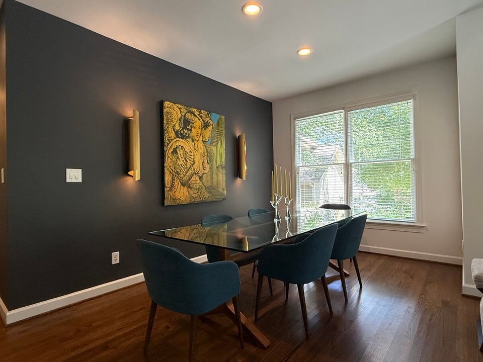 dining room area in a custom home in wake county nc with dark wood floors and custom wall lighting