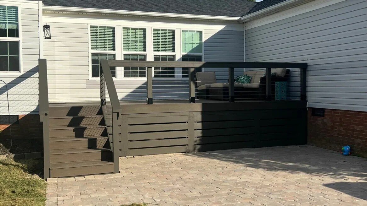 Backyard deck with dark wood finish and cable railing built by Triple Crown Contractors in Apex, NC