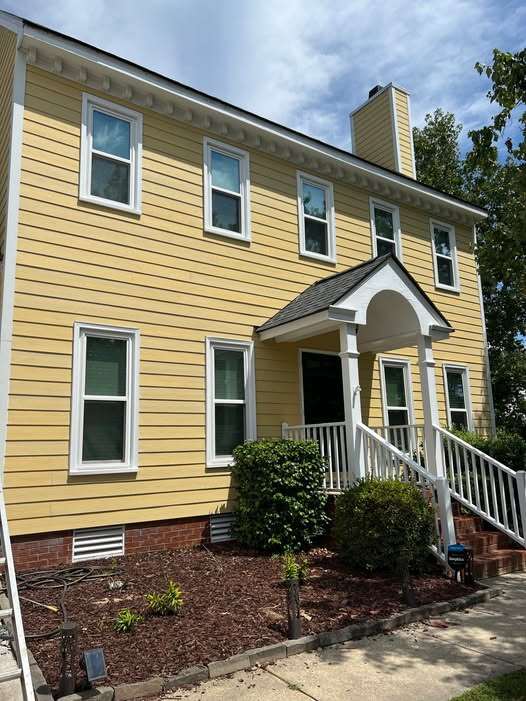 Freshly remodeled yellow two-story home with white trim in Raleigh, NC, by Triple Crown Contractors