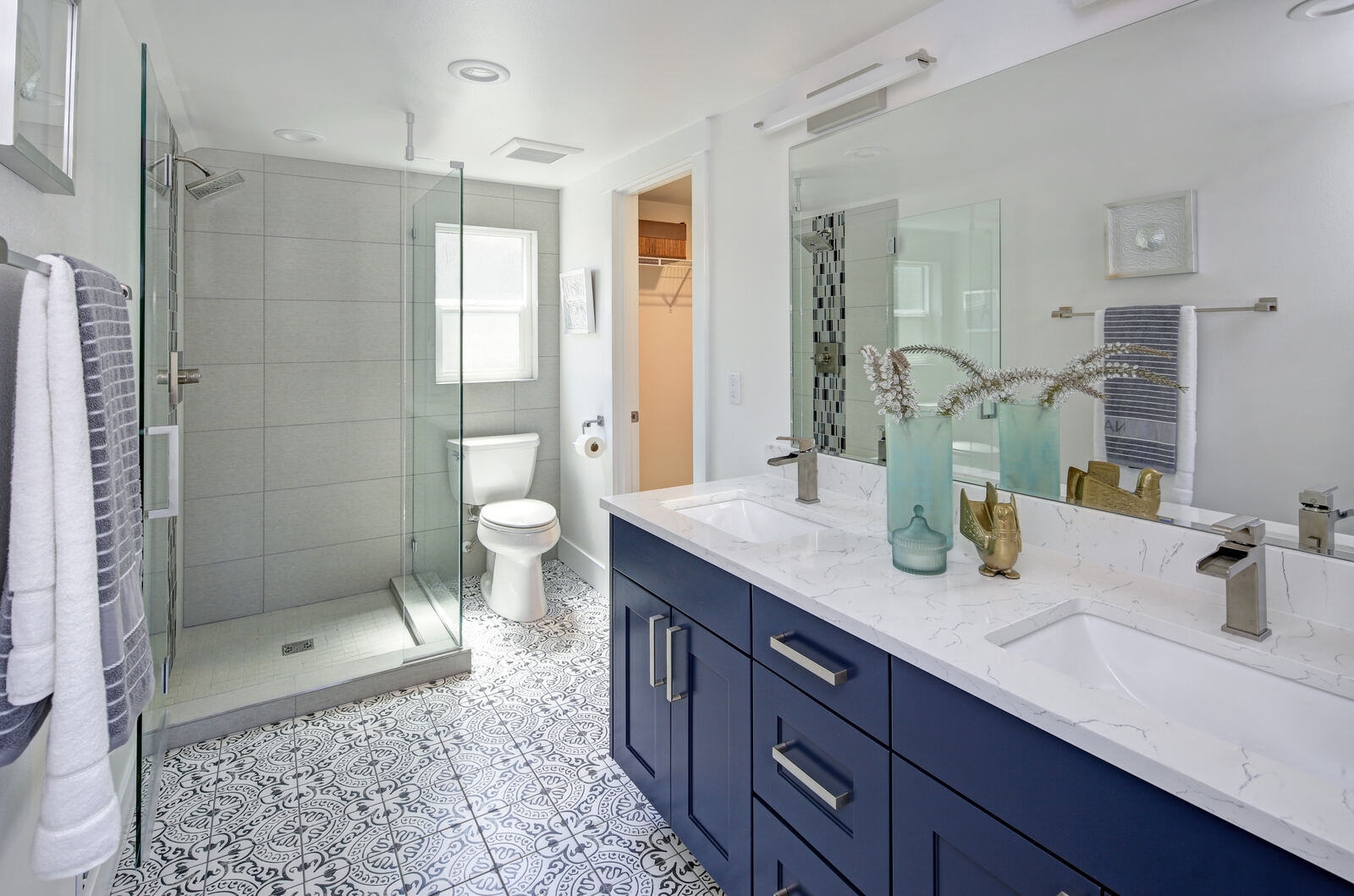 Stylish bathroom remodel featuring a bold blue double vanity and a walk-in glass shower in Durham, NC